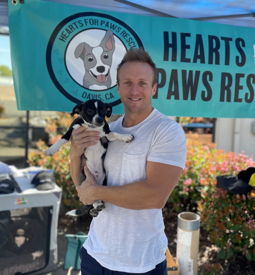 Jeff Bolton holding a rescue dog at Hearts for Paws event